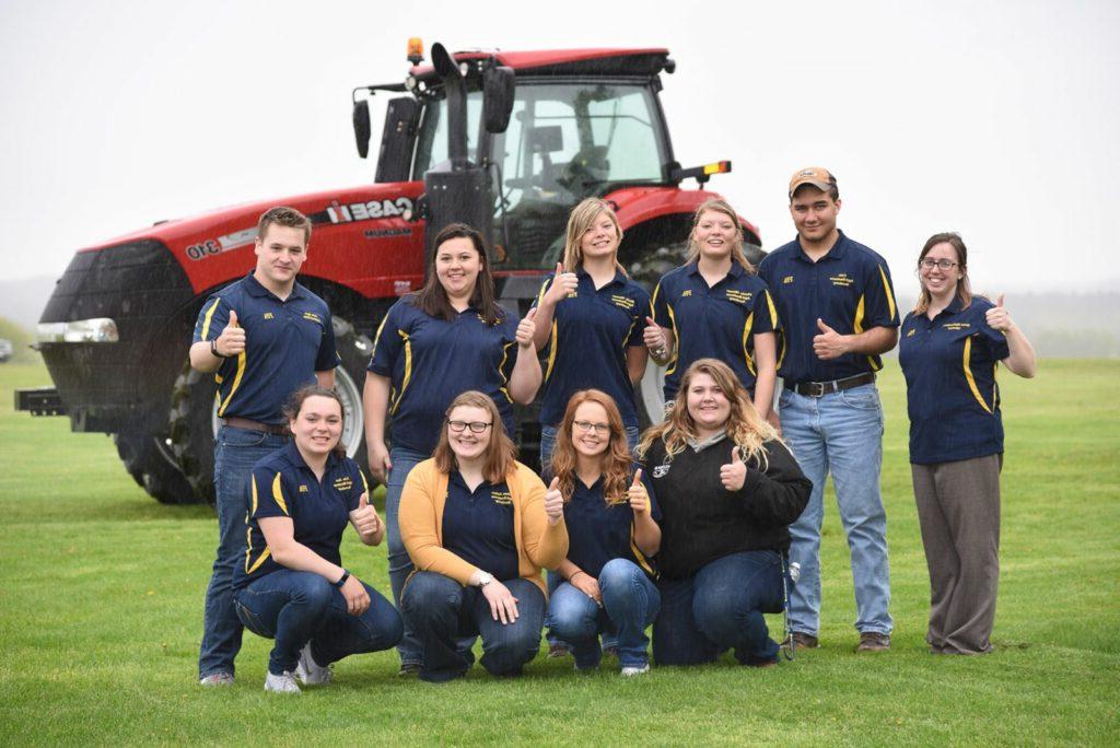 A group of students by a tractor